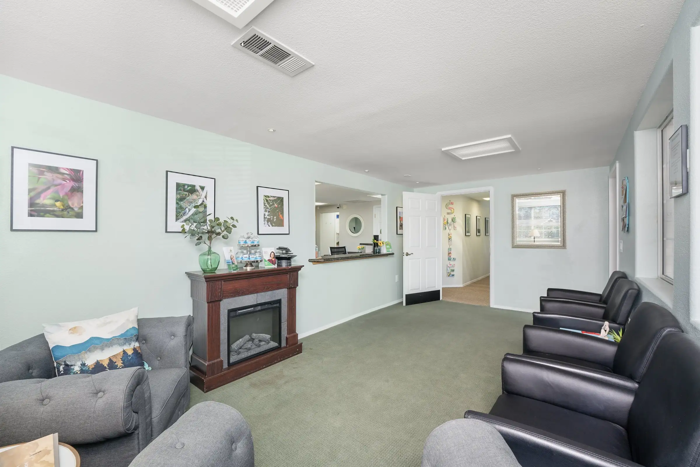 The patient lounge at Alta Vista Dental Care, with a fireplace and comfortable armchairs