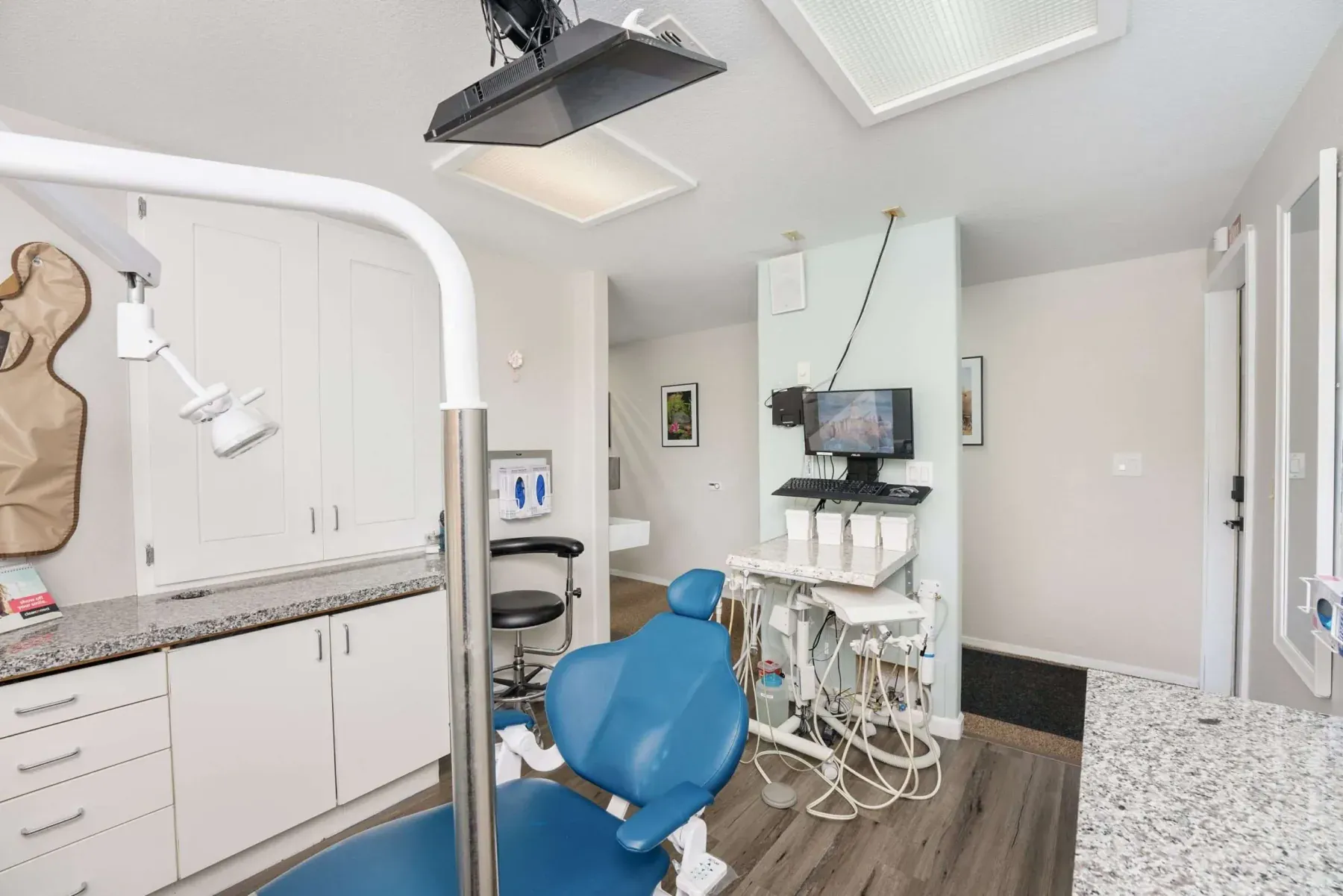 A treatment room with a blue dental chair and chairside monitor at Alta Vista Dental Care